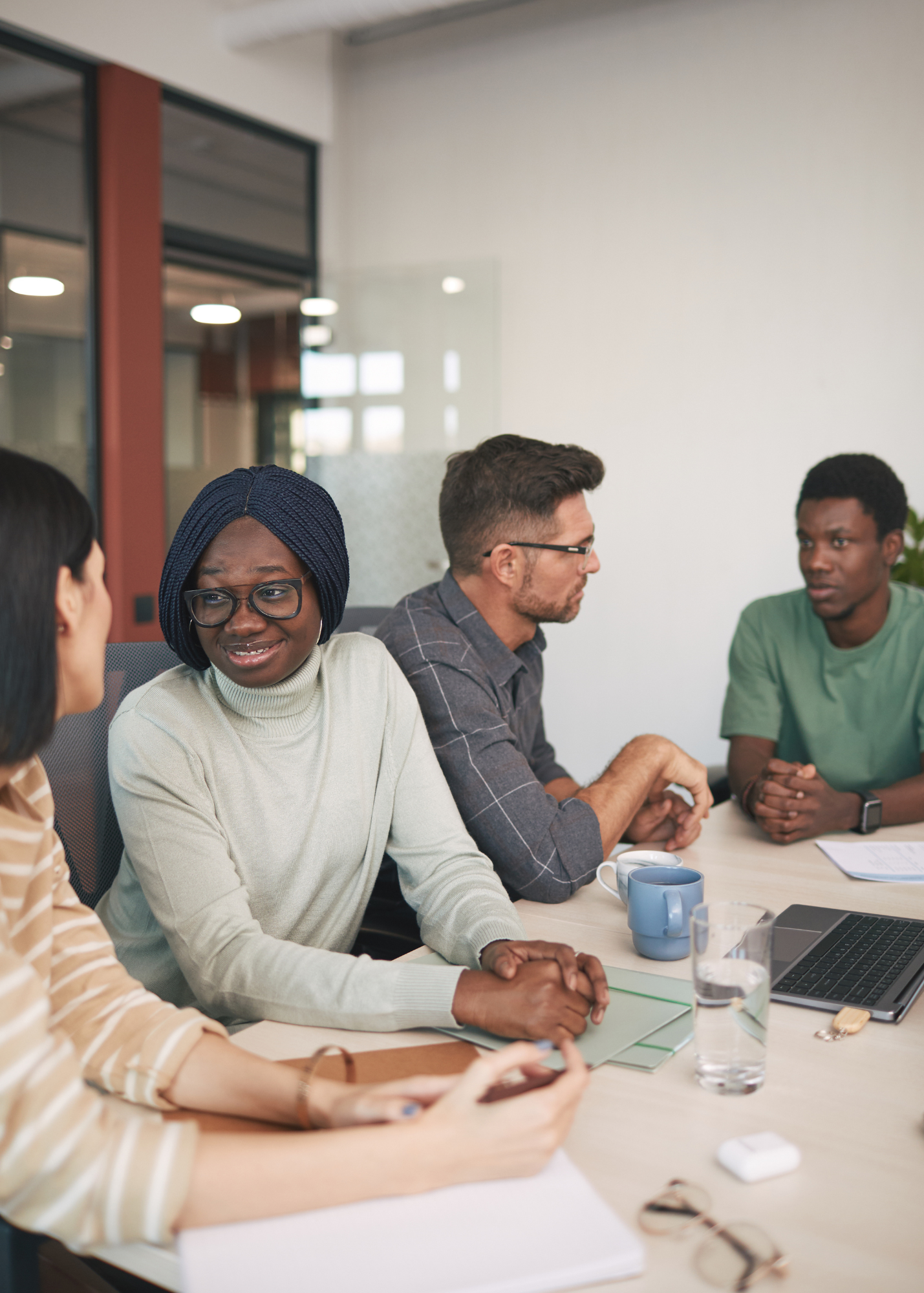 Four people have a work meeting in a relaxed and humanizing workplace